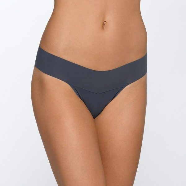 A model shown from the waist down wears the Hanky Panky Bare Natural Rise thong in slate, which is a bluish dark gray. It is a seamless thong panty.