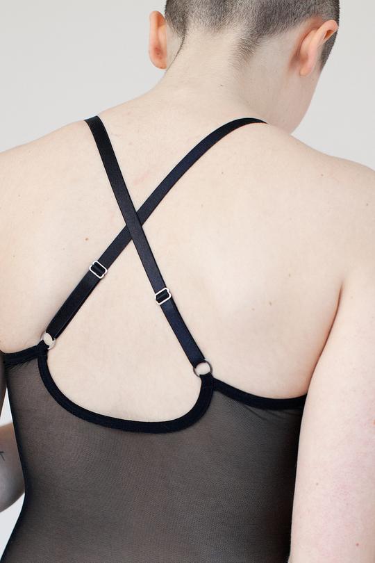 the back view of the Iona bodysuit. It features criss-crossed adjustable straps and the back of the bodysuit made of black mesh.