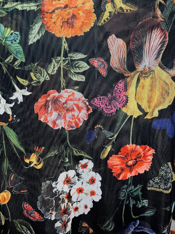 close up of the kilo brava botanical garden mesh fabric - black background with a floral print