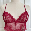 a mannequin posed with red lingerie. the mannequin wears the only hearts so fine lace coucou peek-a-boo bralette. the mannequin is in front of a white door.