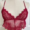 a mannequin posed with red lingerie. the mannequin wears the only hearts so fine lace coucou peek-a-boo bralette. the mannequin is in front of a white door.