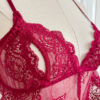 a mannequin posed with red lingerie. view of the bust of the mannequin wearing the only hearts so fine lace coucou peek-a-boo bralette. the mannequin is in front of a white door.