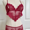 a mannequin posed with red lingerie. the mannequin wears the only hearts so fine lace coucou peek-a-boo bralette and the matching coucou culotte brief. the mannequin is in front of a white door.