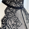 close view of the top of a mannequin's neck showing the black lace details of the only hearts so fine lace halter cami top