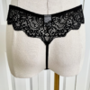 photo of the back side of a mannequin from the waist down in black lingerie. mannequin wears the Only Hearts So fine lace g-string thong panties in black lace. the mannequin stands in front of a white door