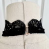 close view of the back of a mannequin's neck showing the black lace and clasp of the only hearts so fine lace halter cami top