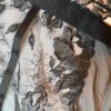 close up view the fabric of the kilo brava black embroidered lace underwire bodysuit.