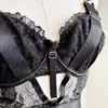 front view of the bust of a mannequin wearing the kilo brava black embroidered lace underwire bodysuit. the mannequin is in front of a white wall.
