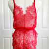 back view of a mannequin wearing red lingerie - the kilo brava eyelash lace teddy in red - stands in front of white doors.
