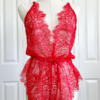 a mannequin wearing red lingerie - the kilo brava eyelash lace teddy in red - stands in front of white doors.
