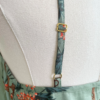 close up view of the strap of the only hearts luv island night dress on a mannequin. this view shows the back shoulder area with gold hardware.