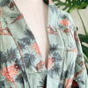 front close in view of a mannequin wearing the only hearts luv island kimono robe in moss green with a tropical print. This view focuses on the waist-up.