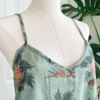 medium view of a mannequin wearing the only hearts luv island night dress in moss green with a tropical print. This view focuses on the top half and bust of the dress. The mannequin stands in front of a tropical plant and white doors.