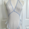 front view of a mannequin wearing the only hearts bettie teddy in crystal blue. It's a light blue sheer one piece in a polka dotted pattern. The mannequin is in front of a white door.
