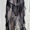 side view of a mannequin dressed with the only hearts coucou lola moonchild dress from the waist down. It's a sheer black lingerie slip dress with a polka dot pattern, three ties at the bust, center front, and waist, and long ruffled skirt. Under the dress the mannequin has on sheer black underwear in the same dotted pattern.