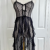 a mannequin is dressed with the only hearts coucou lola moonchild dress. It's a sheer black lingerie slip dress with a polka dot pattern, three ties at the bust, center front, and waist, and long ruffled skirt.