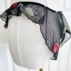 Mannequin wearing black sheer lingerie with rose embroidery and ruffled edges, the only hearts A Rose is A Rose butterfly brief, set against a white background.