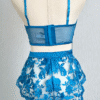 back view of kilo brava embroidered lace longline bralette and tap shorts in Hawaiian blue. Bra and shorts pictured on a mannequin in front of a gray backdrop