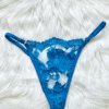 flatlay image of kilo brava embroidered lace g-string thong in Hawaiian blue on a white fur carpet